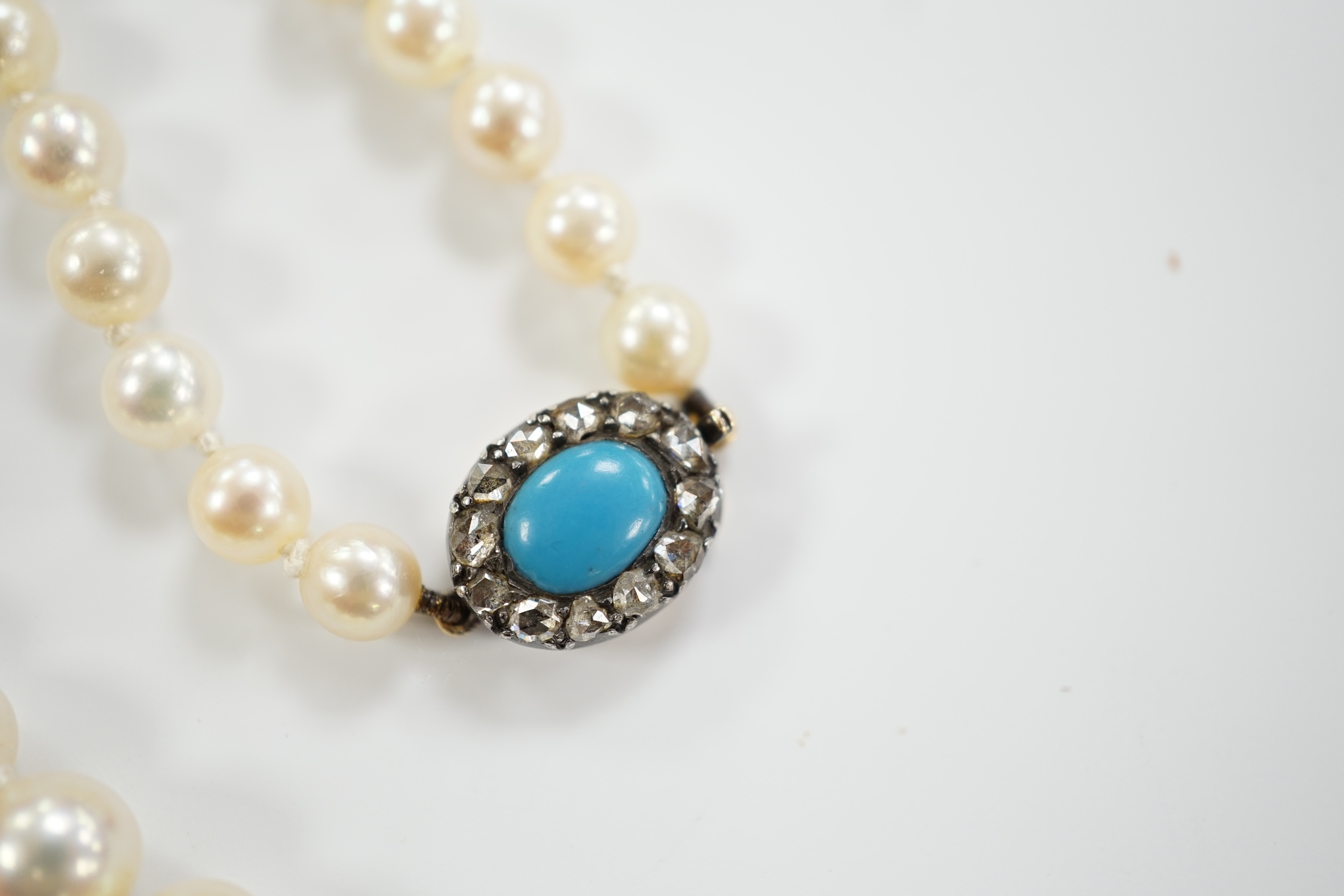A single strand graduated cultured pearl necklace, with turquoise and diamond set yellow metal clasp, 58cm.